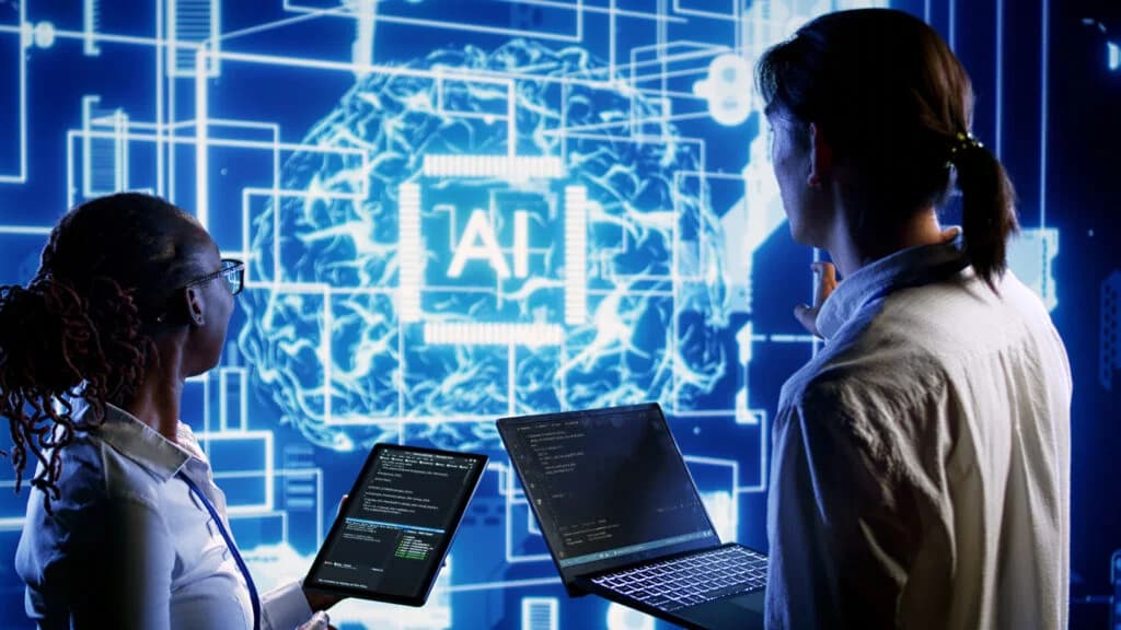 Deux personnes devant un écran schématisant un système d’intelligence artificielle.